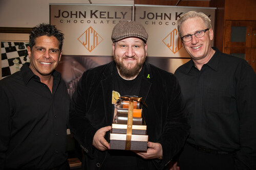A happy Stephen Glickman ("Big Time Rush") embraces a Tower of John Kelly Chocolates with John Kelson and Kelly Green, owners of the company.