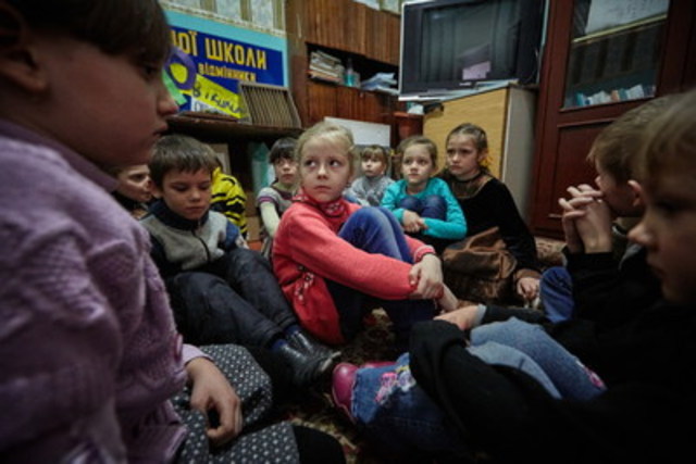 On February 13, 2017, first grade students, including six-year-old Sasha (in red sweater), hide during shelling in a part of the school building with strong walls. The school does not have a basement which can be used as a bomb shelter. Sasha’s house is located some 15 kilometers from the contact line in Toretsk, Donetsk Region, Ukraine. Sasha and her sister, Diana, have been living with their grandmother in this house since the beginning of the conflict in 2014 while their parents live in Donetsk city where they work. © UNICEF/UN053119/Zmey (CNW Group/UNICEF Canada)