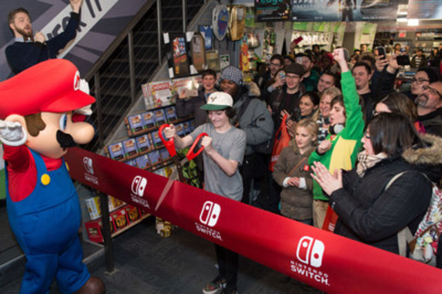 L'acteur canadien Finn Wolfhard, célèbre pour son rôle dans Stranger Things sur Netflix, avec Mario et plusieurs fans au lancement de la Nintendo Switch à Toronto le 3 mars 2017 à minuit. La Nintendo Switch peut changer d'une console de salon à une console portable en un tour de main.
