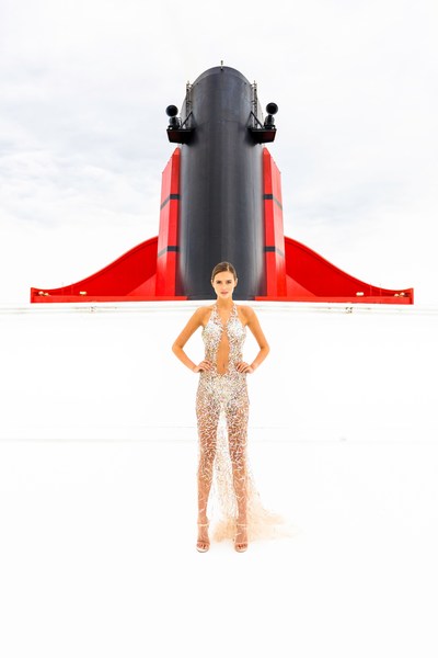 Award winning British fashion designer Julien Macdonald OBE sets sail in style on board Cunard's luxury ocean liner Queen Mary 2 for the first day of Transatlantic Fashion Week 2017. Model wears a signature embellished dress by Macdonald.© Christopher Ison