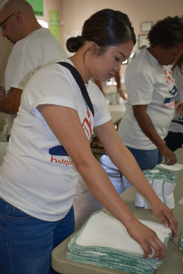 A Nellis Family Housing employee giving a helping hand at Clean the World. This day of service by Nellis Family Housing included over 154 hours of service and the folding of over 14,000 washcloths.