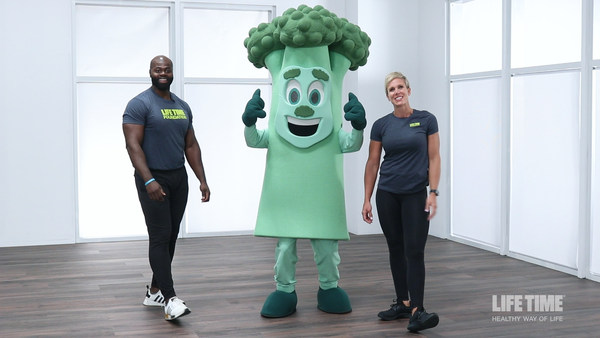 Two smiling personal trainers stand next to a happy broccoli mascot with its thumbs up