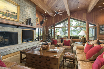 The open-plan residence boasts spacious entertaining spaces, many of which are ornamented with sandstone fireplaces, exposed beams, and walls of windows designed to maximize the awe-inspiring views of the surrounding land. DurangoLuxuryAuction.com.