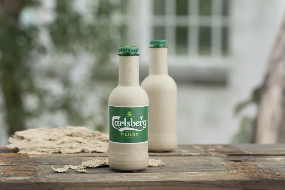 Carlsberg moves a step closer to creating the world’s first ‘paper’ beer bottle. Pictured are the two new research prototypes for Carlsberg’s Green Fibre Bottle, which both contain beer for the first time and are shown alongside the sustainably-sourced wood fibre they’re made from.