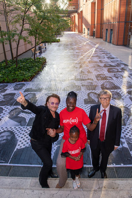 Bono, Co-Founder, (RED), AIDS activist Constance Mudenda, alongside her daughter, Lubona and Bill Gates, Co-Chair, the Bill & Melinda Gates Foundation, are photographed at an installation by the Inside Out Project in Lyon. The installation features the faces of 850 people who support the fight to end AIDS - the same number of women who contract HIV each day. 