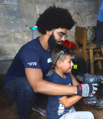 AMN Healthcare team member and Team Hope volunteer Kendrick Azubuike gets help from a young Guatemalan in building a safety stove for his home. Team Hope, sponsored by AMN Healthcare, installs safety stoves that vent toxic smoke outside the home, reducing the risk of eye and respiratory disease. Safety stoves also use a fraction of the wood of commonly used open fires, which reduces deforestation and the carrying of heavy wood loads that lead to hernias and other musculoskeletal  injuries.