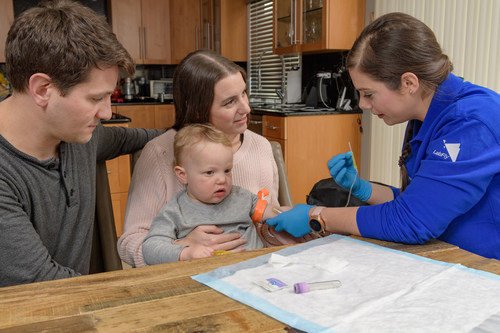 Northwell Health Labs Phlebotomist Dina Durdu (far right) prepares a blood draw for a toddler in the privacy and convenience of his own home with mom and dad by his side. Credit Northwell Health.