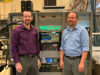 Evan Groopman (left), a research physicist and Dr. David Willingham (right), a research chemist and head of the Accelerator Mass Spectrometry Section, gather in front of the NAUTILUS instrument in the Accelerator Mass Spectrometry Laboratory at the U.S. Naval Research Laboratory in Washington, D.C., Sept. 5. (U.S. Navy photo by Nicholas E. M. Pasquini)