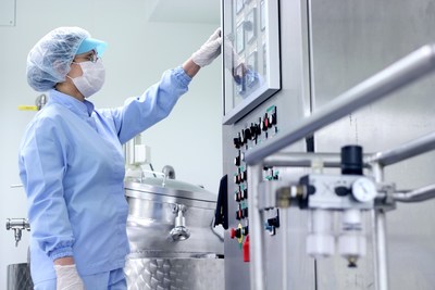 Pharmaceutical technician working in sterile working conditions at pharmaceutical manufacturing facility. Pharmaceutical technician working in sterile working conditions at pharmaceutical manufacturing facility.