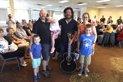 Leah (in the middle) with her family and Paul Langlois (right) from The Tragically Hip, at her wish reveal in Kingston, ON. in July 2019 with Pita Pit Canada. (CNW Group/Pita Pit Canada)