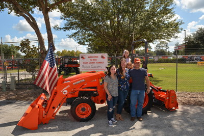 Marine Corps veteran Russell Guzzetta, who owns and operates Country Song Farm in Lithia, Florida, stands with his family in front of the Kubota L Series compact tractor he was awarded through Kubota's Geared to Give program during a special ceremony October 3.