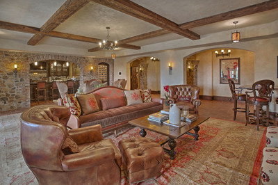 Cozy and inviting, the lower-level lounge (pictured here) offers a temperature-controlled wine cellar and wet bar, and is just down the hall from the home theater, digital golf simulation room and an additional kitchen. NewJerseyLuxuryAuction.com.