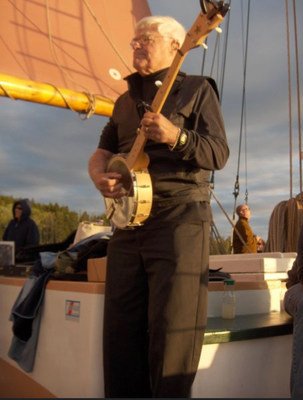 George Swanson playing the banjo on the schooner, the Margaret Todd. Photo Credit: Katrina Swanson circa 2004
