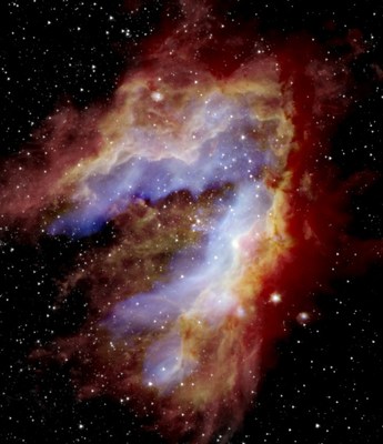 Composite image of the Omega Nebula. SOFIA detected the blue areas (20 microns) near the center. The red areas near the edge represent cold dust detected by the Herschel Space Telescope (70 microns), while the white star field was detected by the Spitzer Space Telescope (3.6 microns). The space telescopes could not observe the blue and green regions in such detail because the detectors were saturated. SOFIA’s view reveals evidence that parts of the nebula formed separately to create the swan-like shape seen today. Image credit: NASA/JPL/SOFIA