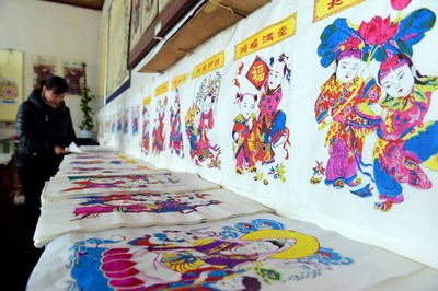 As the New Year approaches, the workshops of the Yangjiabu Woodblock New Year Paintings are getting busy supplying the festival market. In the photo, a worker is sorting out the newly printed New Year paintings.