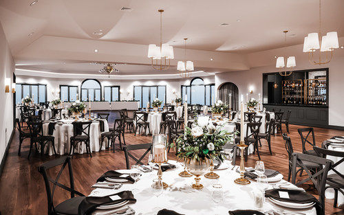 Couples who book Granite Rose by Wedgewood Weddings can enjoy cross-back chairs, modern black accents, contemporary chandeliers, and elegant wood flooring.
