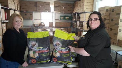 Athens County Food Pantry President Karin Bright and Petland Athens General Manager Sally Jo Kuntz holding bags of Petland's Heartland Naturals dog food. Petland will be donating more than $10,000 in pet food to the pantry over the next six months.