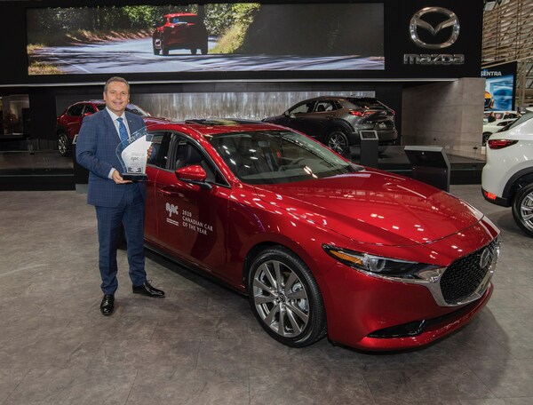 David Klan, président et chef de la direction, Mazda Canada, tient le trophée de la Voiture canadienne de l’année 2020 décerné par l’AJAC devant la Mazda3 primée. (Groupe CNW/Mazda Canada Inc.)