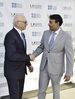 Dr. Stephen D. Nimer (left), director of the Sylvester Comprehensive Cancer Center, and Dr. Amit Rastogi, president and CEO of Jupiter Medical Center, shake hands to celebrate the affiliation agreement between the two organizations.