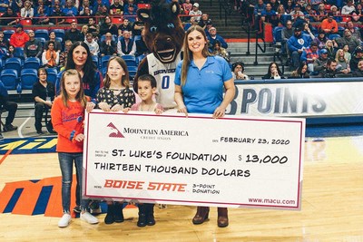 Angela Phillips of Mountain America presents to Sherry Iverson, St. Luke's Children&rsquo;s Director of Community Education alongside Buster Bronco at Boise State University during the February 23 game.