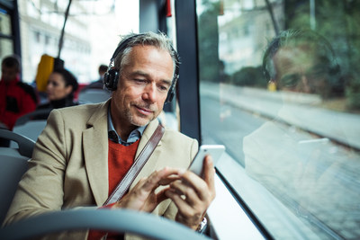 Man on a Bus looking at his smartphone (CNW Group/FlightHub)