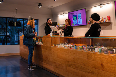 Customer making a purchase at Lux Pot Shop's newest location in Seattle's Fremont neighborhood