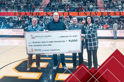 Jason Smith of Mountain America presents the check to Troy Eppich of Bingham Health Care Foundation, alongside representatives of BHCF.