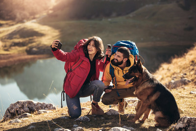 A couple taking a picture with a dog (CNW Group/FlightHub)