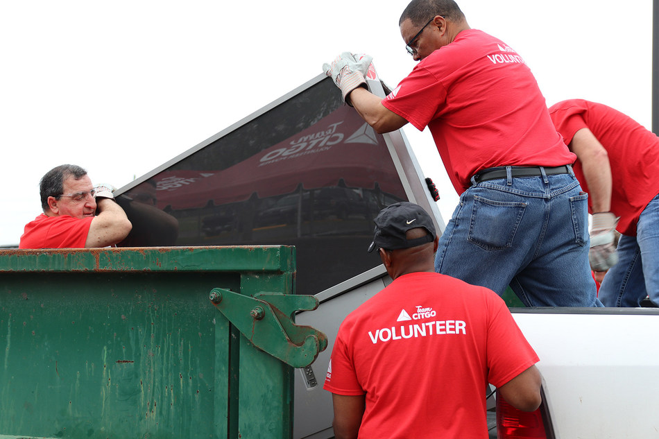 TeamCITGO volunteers load e-waste into roll-off boxes during CITGO E-Recycle Day at the McNeese Cowboy Stadium parking lot.