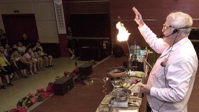 Dr David G. Evans is demonstrating a chemical reaction to Chinese elementary school students