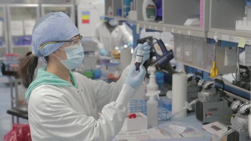 A lab technician checking blood sample details.