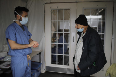 Photo credit: Brian Snyder/Reuters.  A medical staffer from Boston Healthcare for the Homeless speaks with a patient. The organization received a portion of Liberty Mutual’s $15 million grant benefitting organizations working to help the most vulnerable populations impacted by COVID-19.