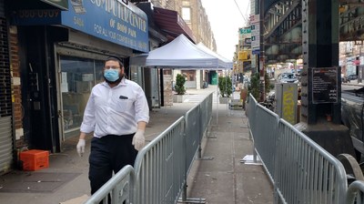 Masbia Volunteer, Mendel Teitelbaum, walking past the social-distancing metal-barriers placed by NYC Office of Emergency Management (OEM) for the swelling breadline in front of Masbia of Boro Park