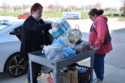 Charlene Dellipoala (left) and Julie Tanner of the LCCC Commodore Cupboard load donated food for the campus food pantry.