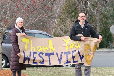 Parents hold a thank you sign outside the Melmark New England Residence as staff complete their eight-day shift.