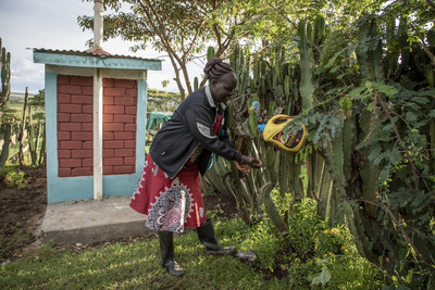 A villager in Kenya demonstrates her handwashing station next to a latrine made of interlocking bricks - a local market-based solution for sustainable sanitation. WSSCC/Jason Florio