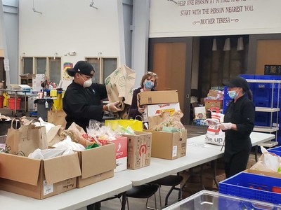 Staff members from Cathedral Kitchen help sort food and supplies for the organization’s to-go meal program.
