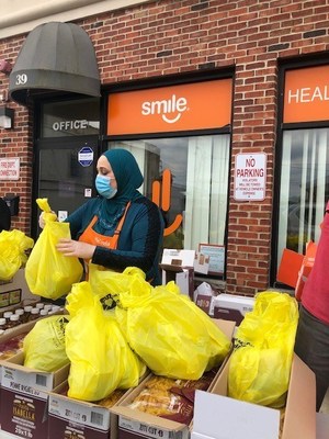 A volunteer helps distribute food packages at SMILE for Charity Food Pantry in Passaic County.