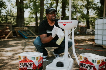 Giant Terence Lester, Founder of Love Beyond Walls, cleans one of many portable handwashing stations that he sets out for Atlanta’s homeless.