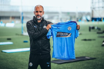 Manchester City manager Pep Guardiola shows off matchday shirt for Premier League return.