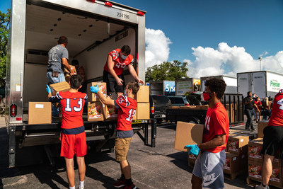 Volunteers with Cornerstone church, including Cornerstone Christian Schools football players, unload a truck at the church's food distribution event this past weekend. Credit: Hagee Ministries.
