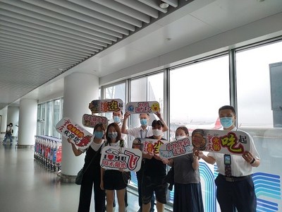 The passengers landing in Chongqing hold high the slogan 