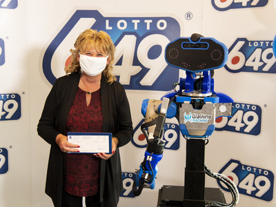 Winner Guylaine Desjardins with SARA, the robot designed, developed and controlled by the ÉTS’s Walking Machine student club (CNW Group/Loto-Québec)
