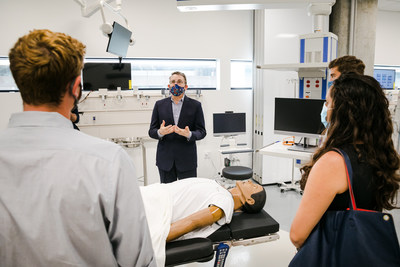 Mark Schuster, MD, PhD, Founding Dean and Chief Executive Officer of the Kaiser Permanente Bernard J. Tyson School of Medicine, tours the school's simulation lab with several students from its inaugural class.