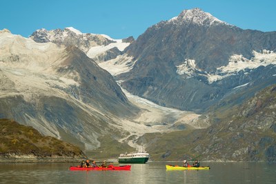 Kayaking glassy Alaskan waters in front of the Wilderness Adventurer.