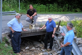 IACMI-The Composites Institute Technology Impact Manager John Unser, second from right, is coordinating a public-private collaboration to install a fiber reinforced polymer composite bridge deck in a rural Tennessee community. From left, are Morgan County (TN) Highway Superintendent Joe Henry Miller, McKinney Excavating (TN) Owner Brian McKinney, and Composite Applications Group CEO Jeff McCay.