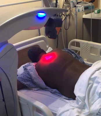 Laser scanner configuration while the patient is in the prone position with scapular protraction. The laser scanner was adjusted 20 cm above the skin as per manufacturer’s guidelines. The patient is shown here with his hands under his head for maximum scapular protraction. The red light is the laser machine’s guide beam on the skin. Infrared lasers with wavelengths of 808 and 905 nm are not visible to human eyes. The 2 sources are coupled in a single system, the MLS laser system.