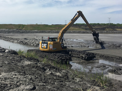 A M.J. Van Damme Inc. excavator digging an Ohio drainage ditch during a springtime restoration project.