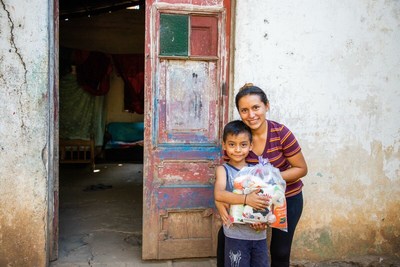 Five-year-old Adonay and his mother, Kirian, receive a food pack from Compassion El Salvador.