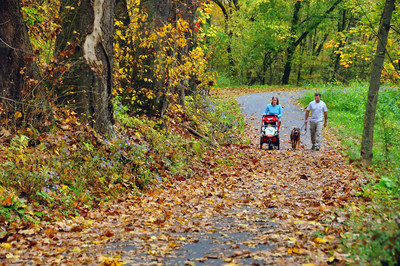 A family walks along the Mon River Trail at Pricketts Fort in West Virginia. The 48-mile Mon River Rail-Trail System, comprising the Mon River, Caperton and Deckers Creek Trails that converge in Morgantown, is the 2020 inductee to Rails-to-Trails Conservancy's Rail-Trail Hall of Fame. Photo by Steve Shaluta, courtesy Mon River Trails Conservancy.